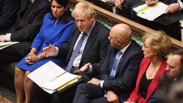 Boris Johnson i Underhuset med statsråder på begge sider. Foto