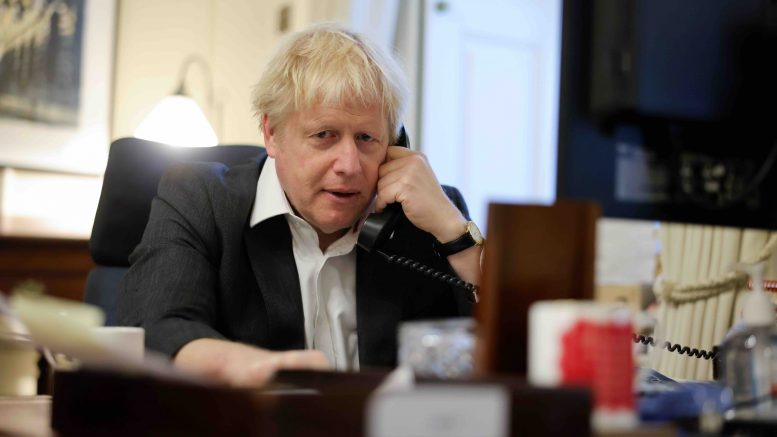 Boris Johnson snakker i telefon. Foto