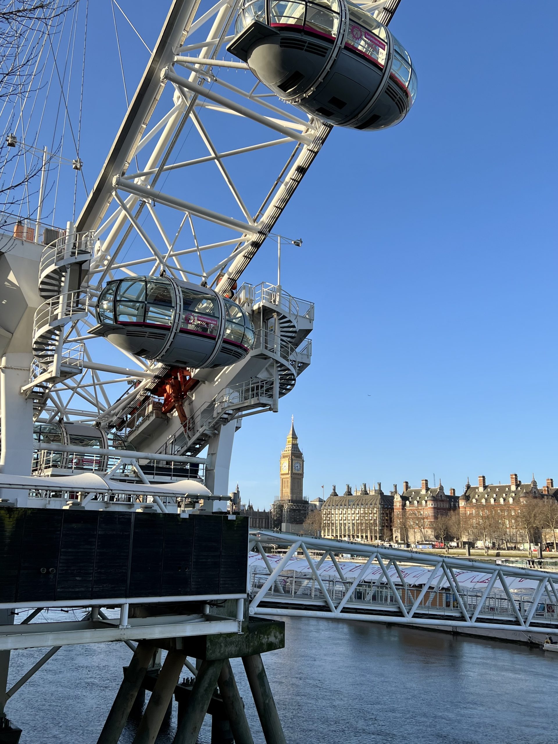 Foto av to av de 32 glasspodene. På den andre siden av Themsen kan en se Big Ben og litt av Parlamentet.