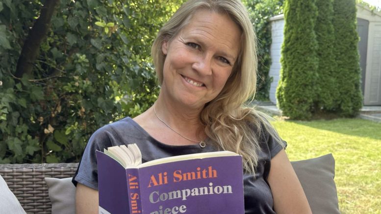 Gry Blekastad Almås med en bok av Ali Smith i fanget. Foto